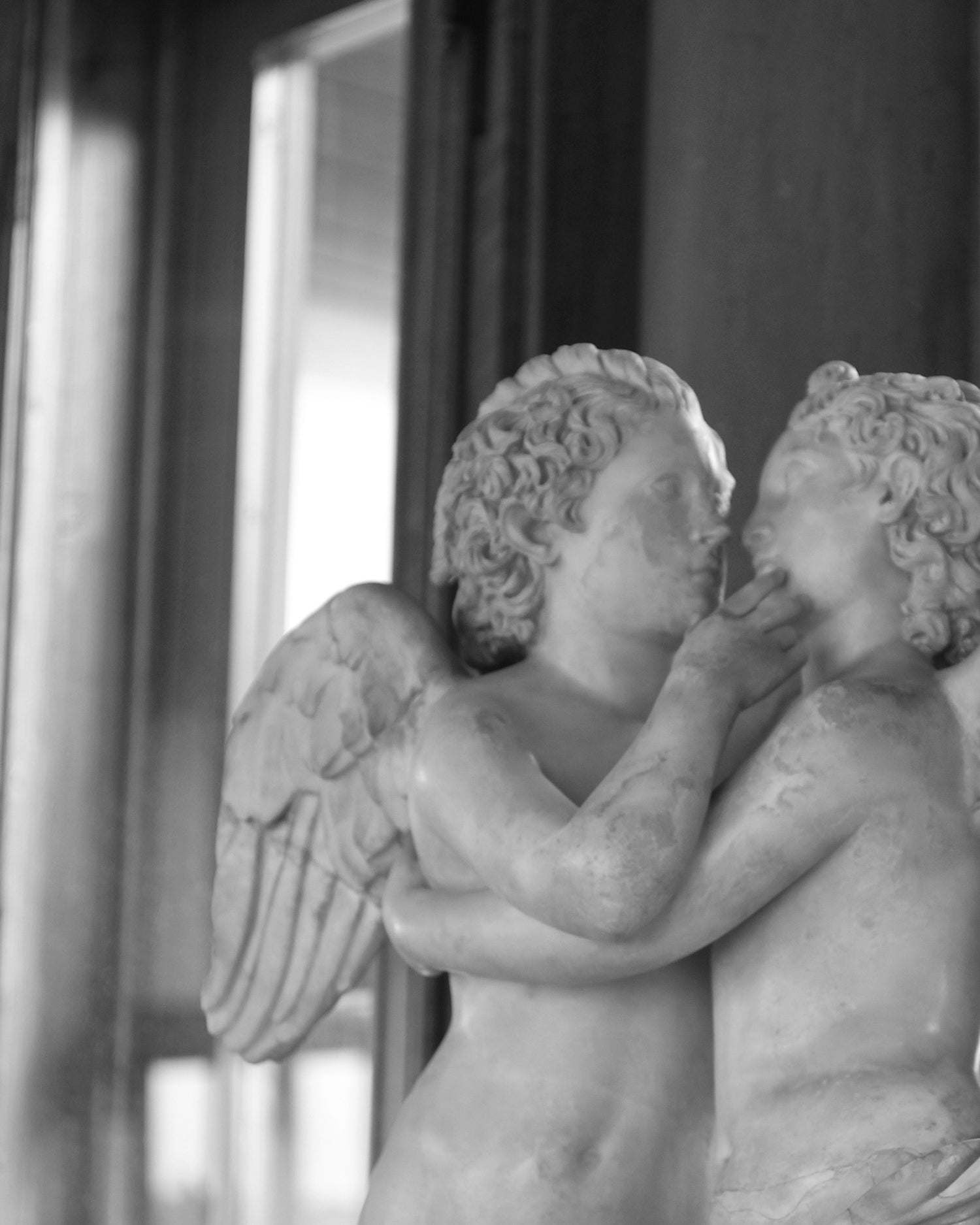 an image of two marble cherubs kissing