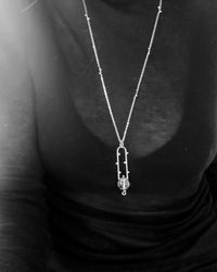 black and white images of a silver necklace against a black shirt