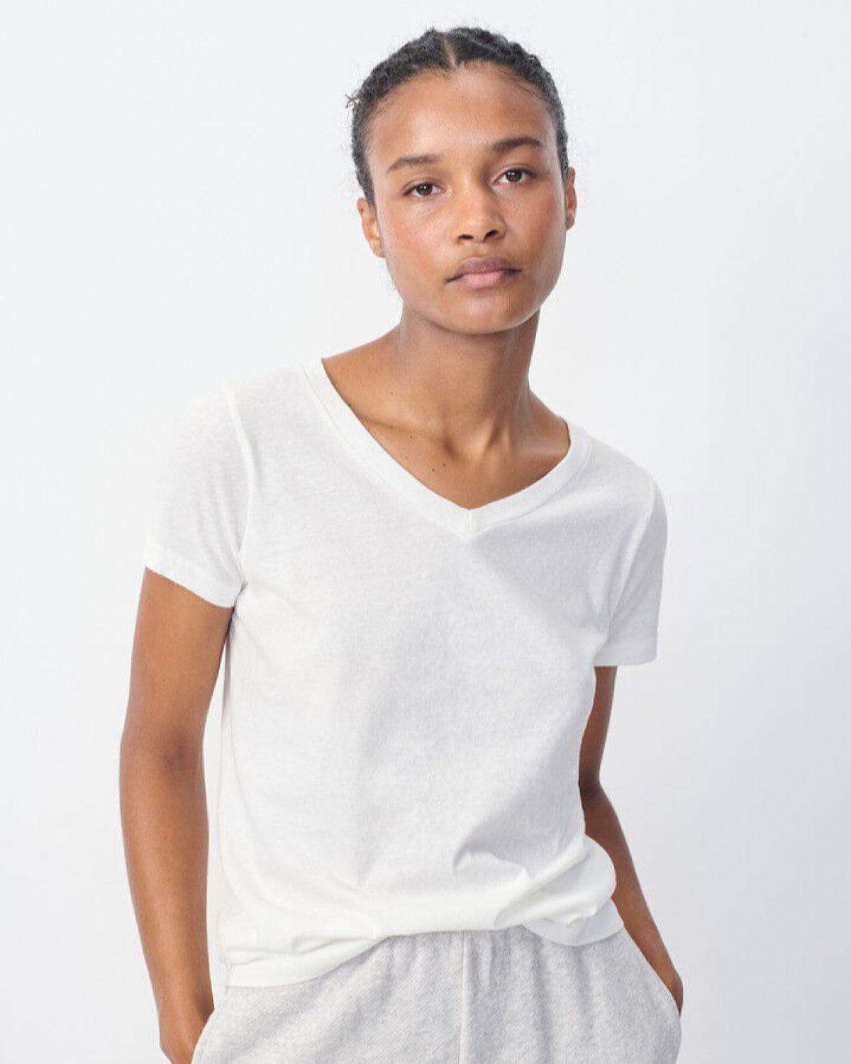 Model wears a white gamipy V neck Tshirt by American Vintage at The Pared Store