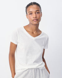 Model wears a white gamipy V neck Tshirt by American Vintage at The Pared Store