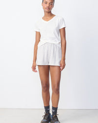 Model wears a white gamipy V neck Tshirt by American Vintage at The Pared Store