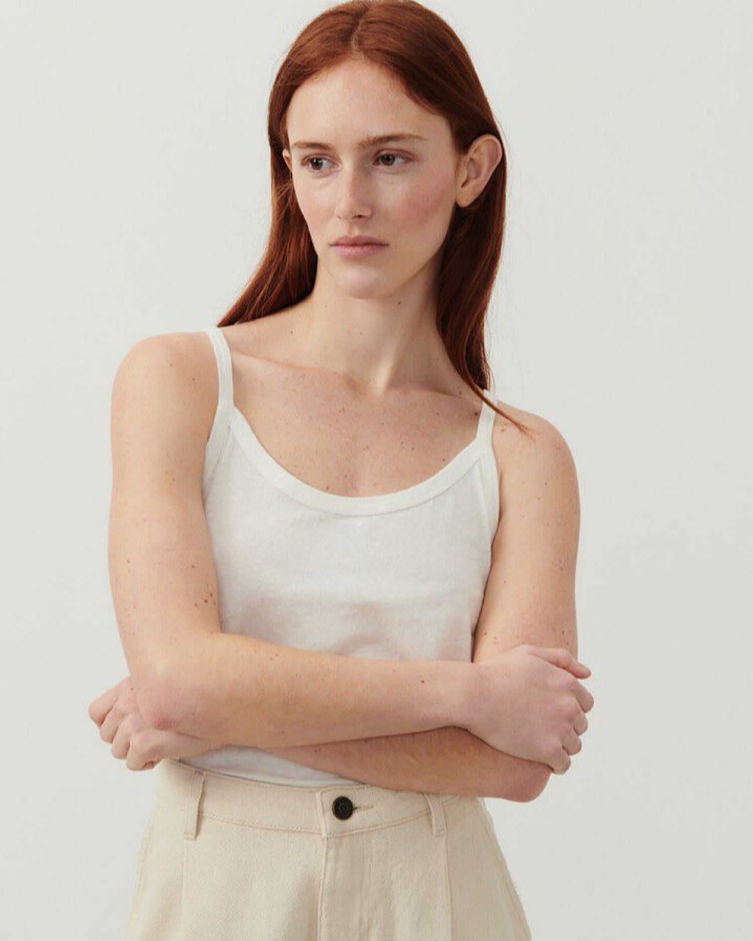 Model wears a thin strap white Gamipy tank top by American Vintage