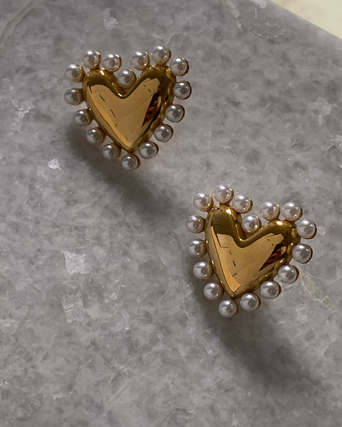 Gold demi earrigs on marble