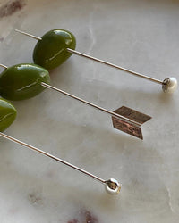 various cocktail picks with olives