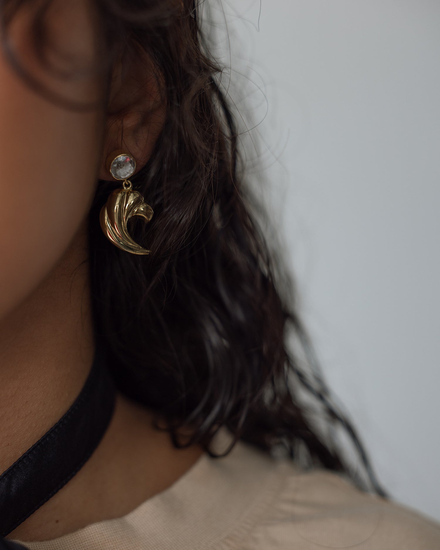 model wears a vintage pair of gold earr9ings with crystal stud top