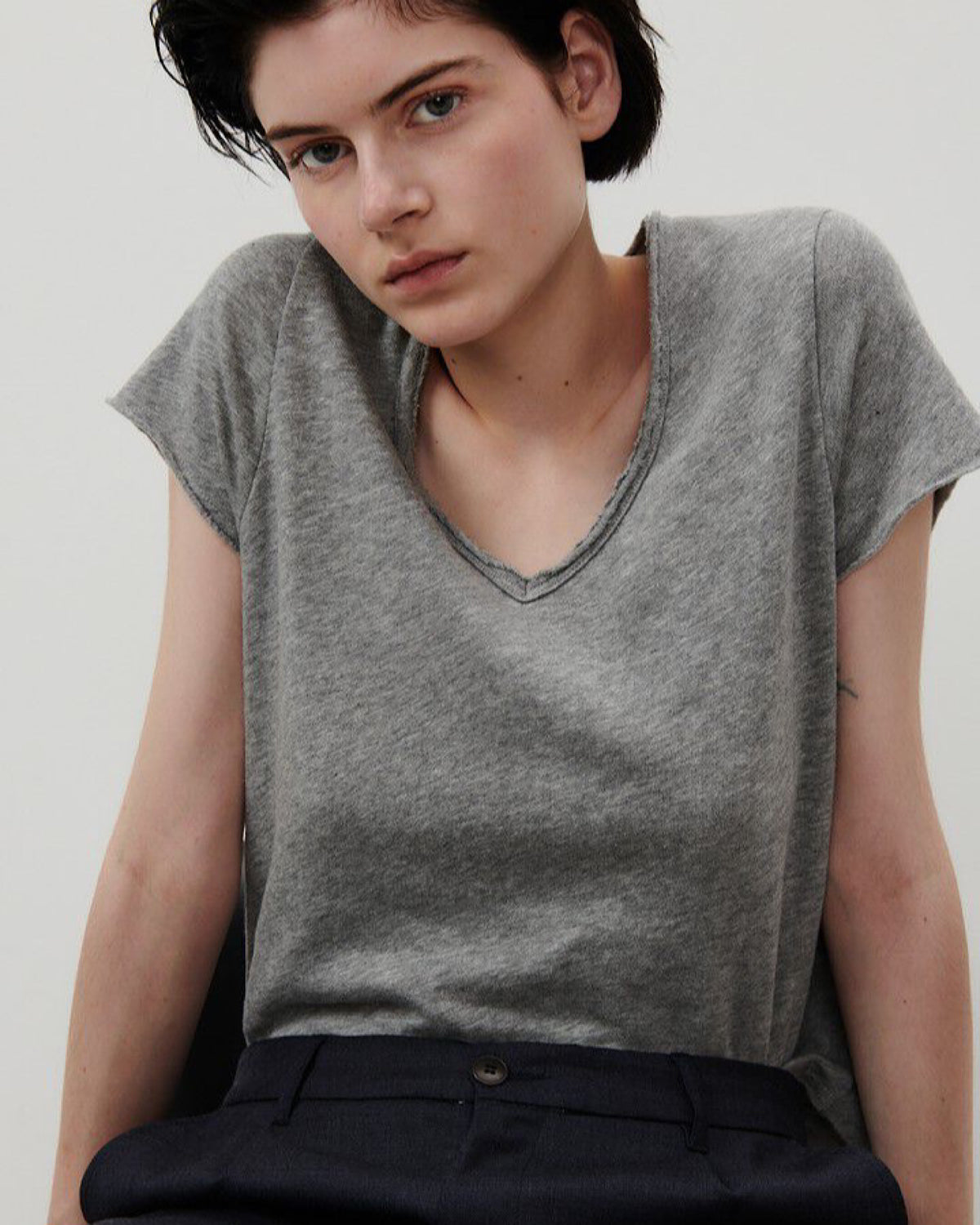 Model wears a V neck T-shirt with raw edging