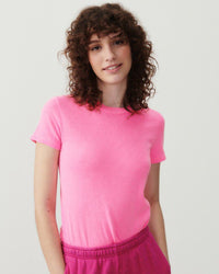 Model wearing a bright pink fitted round neck short sleeve t-shirt from American Vintage