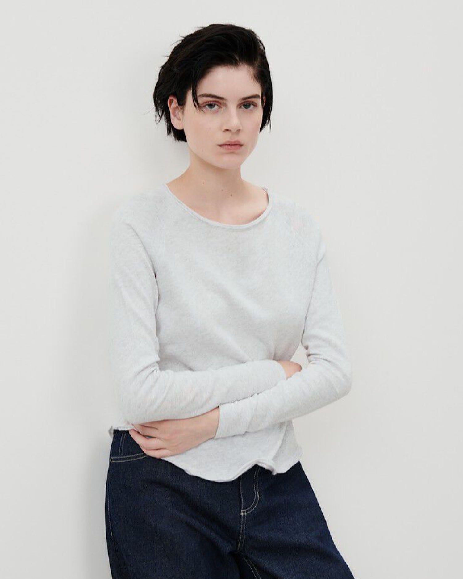 Model wears a boat neck style long sleeve light grey T-shirt from American Vintage