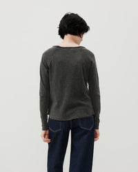 Model wears a boat neck washed pout black long sleeve tshirt and jeans