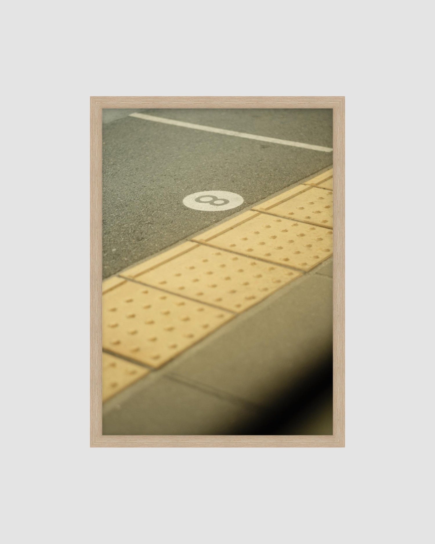 Framed picture of a cement floor with a number 8 on the floor.