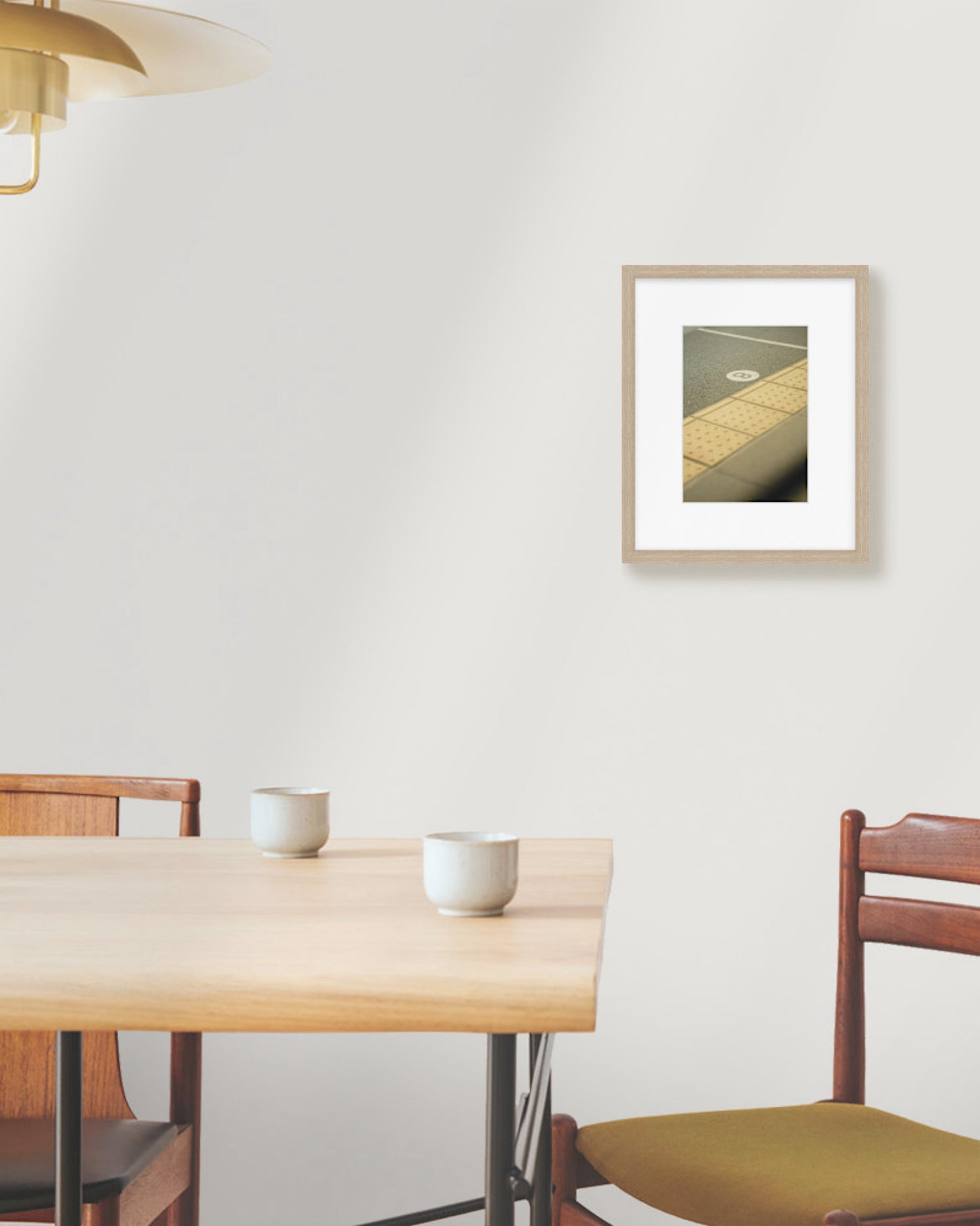Dining area with wooden table, chairs, and framed picture on the wall.