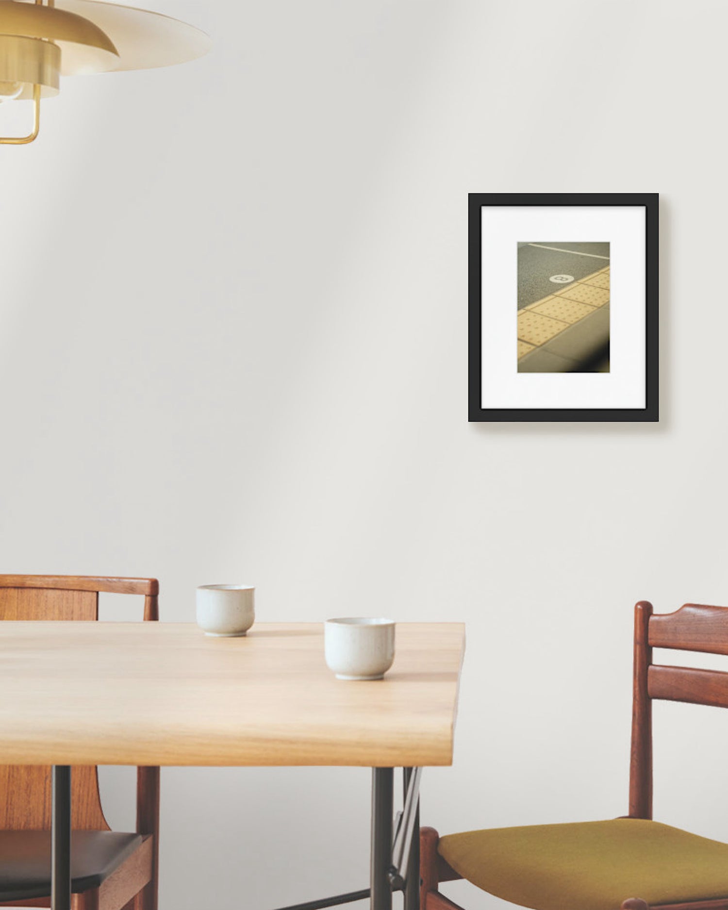 Dining area with a wooden table and chairs, framed picture on the wall.