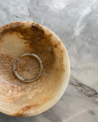 round tube like silver bangle sits in a bowl