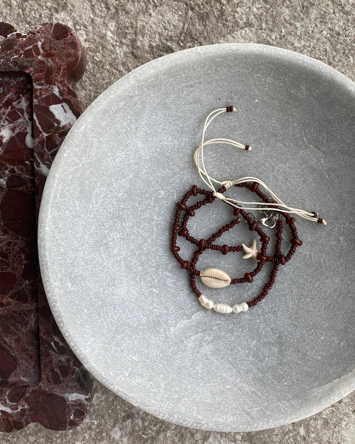 set 3 beaded bracelets with pearls and resin charms in a stone bowl