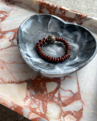 chocolate beaded bracelet with a central dark brown mottled feature bead in a heart bowl