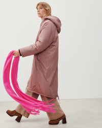 a model walks with a very bright fluro pink scarf