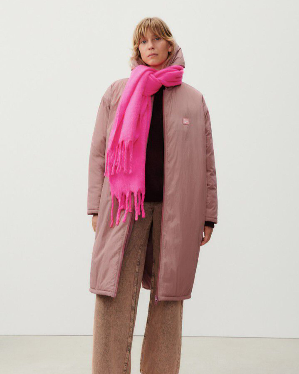 model wears a fluro pink scarf and rose coloured jacket