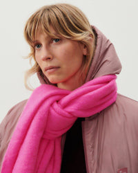 model wears a dusty pink jacket and a hot pink scarf