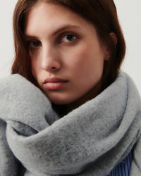 A pale grey marle fringed super soft scarf on a model