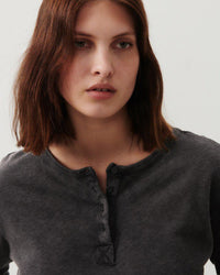 model wears a black cotton henley from American vintage