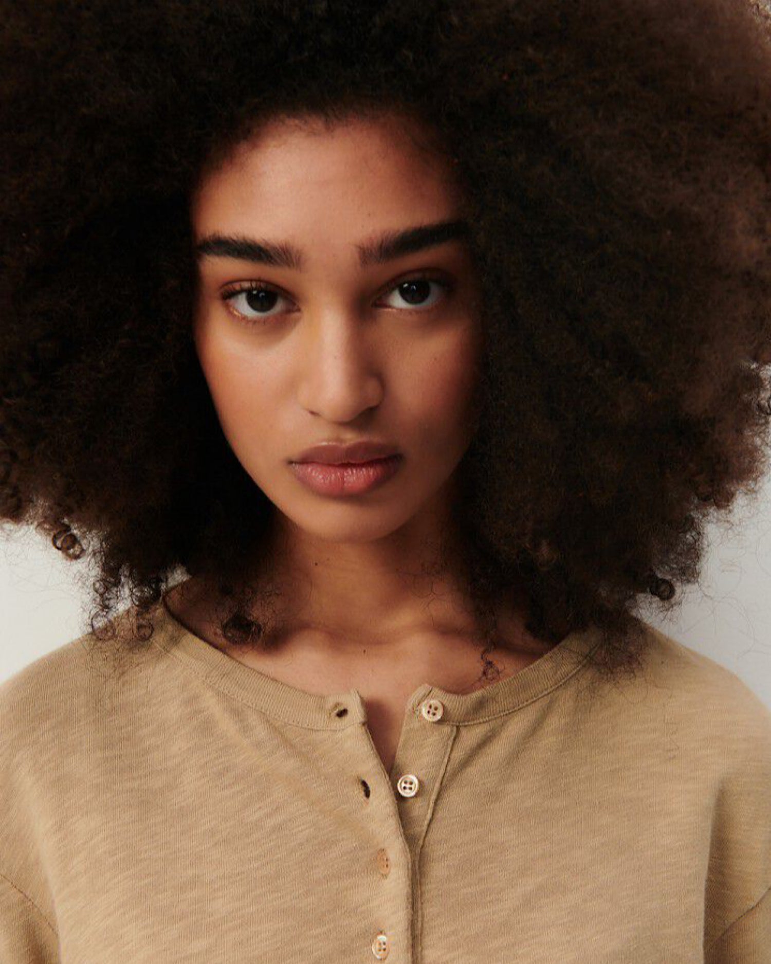 model wears a washed camel cotton henley from American vintage