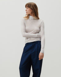 A grey mottled turtleneck on a model in blue pants