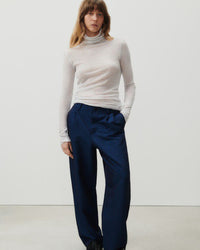 A grey mottled turtleneck on a model with blue pants