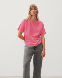 a fluro pink boxy t-shirt on a model