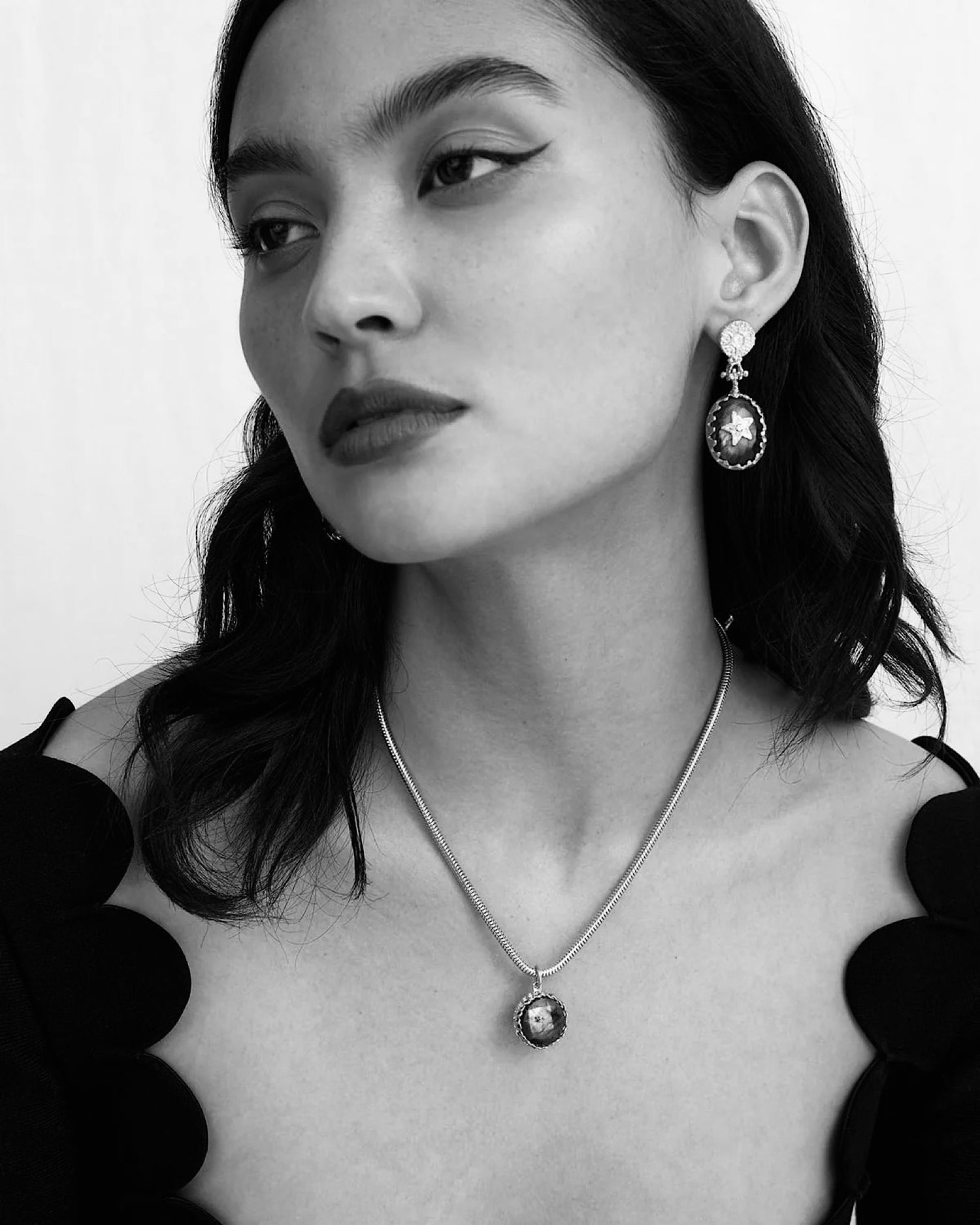 model wears drop earrings featuring a star