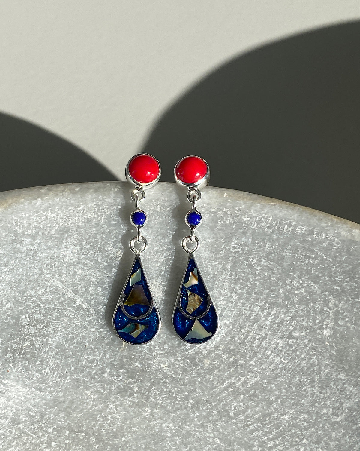 Silver & Coral stud earrings with a blue and blue tear charm hanging of them