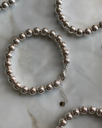 a silver ball bracelet against marble