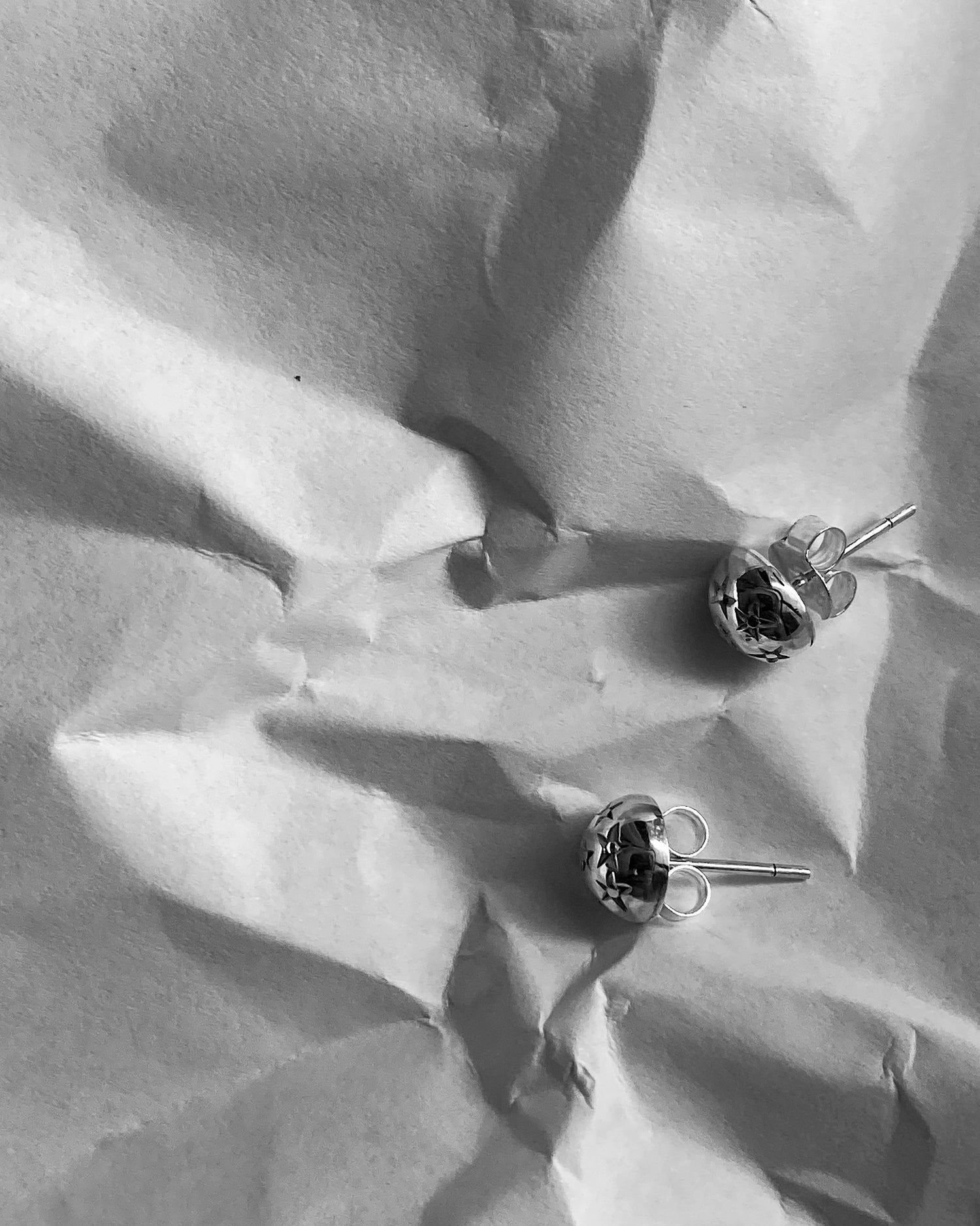 tiny silver stud earrings with stars stamped on them