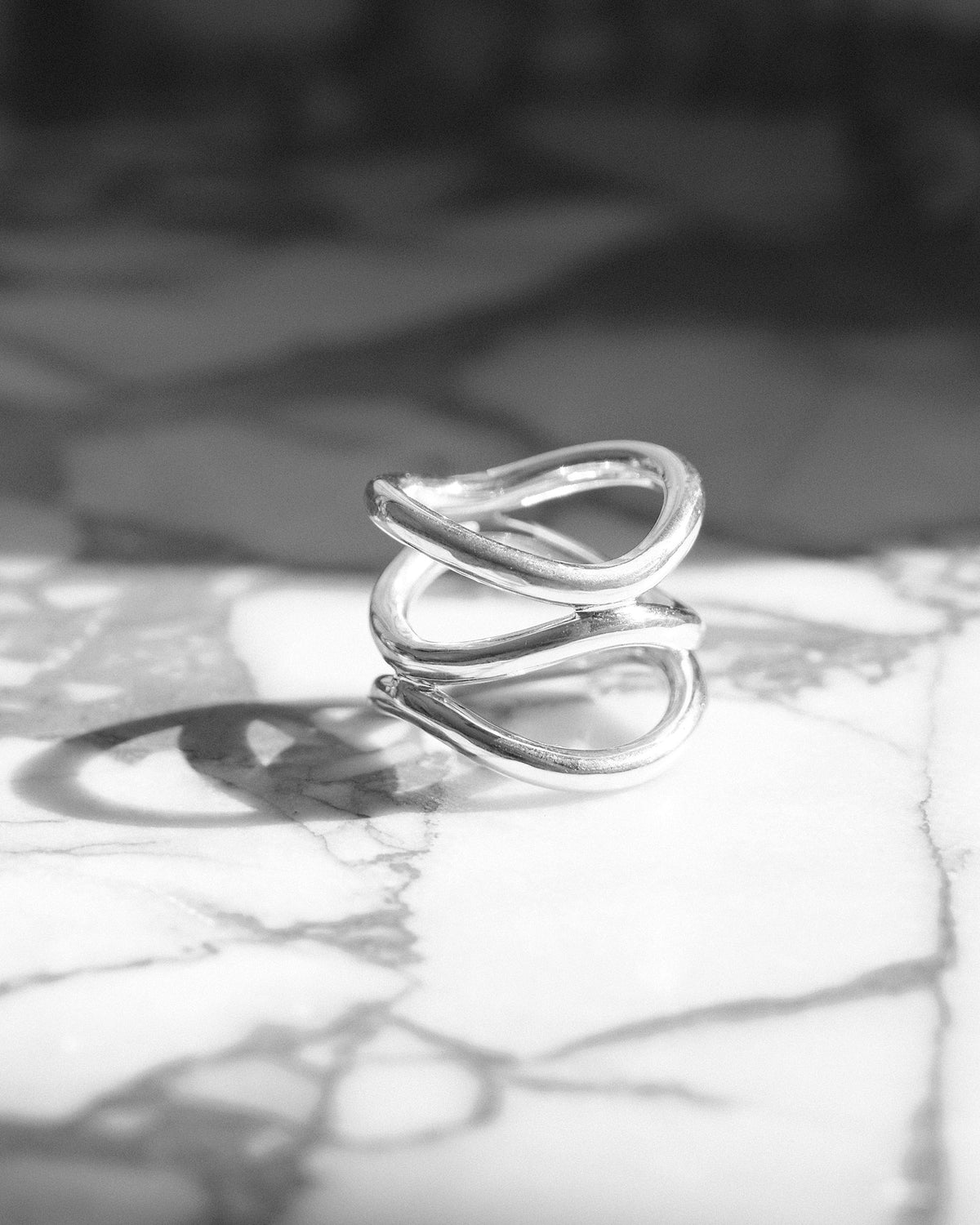 A silver ring made up of a several curved rings joined