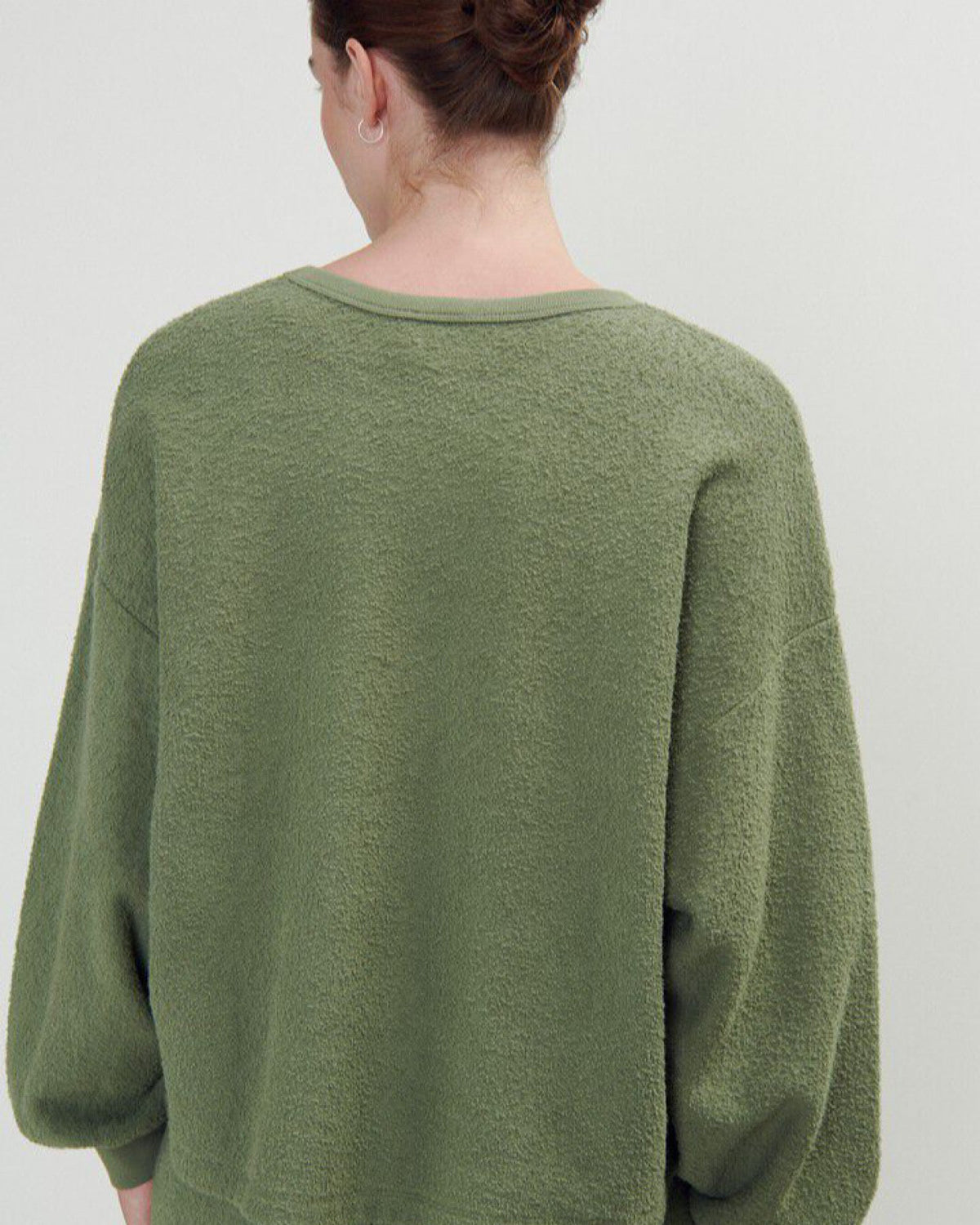 a green boucle style sweatshirt on a model