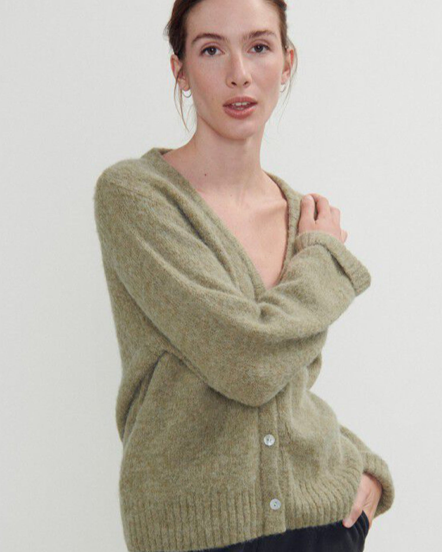 an olive green and grey mottled v neck cardigan with ribbed sleeves and shell buttons