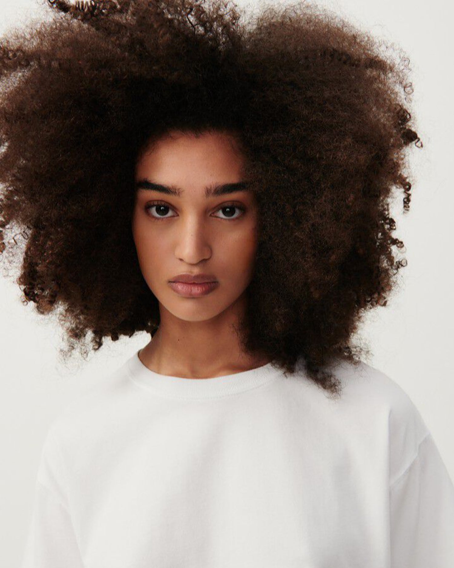 A model wears a white round neck tee with short sleeves