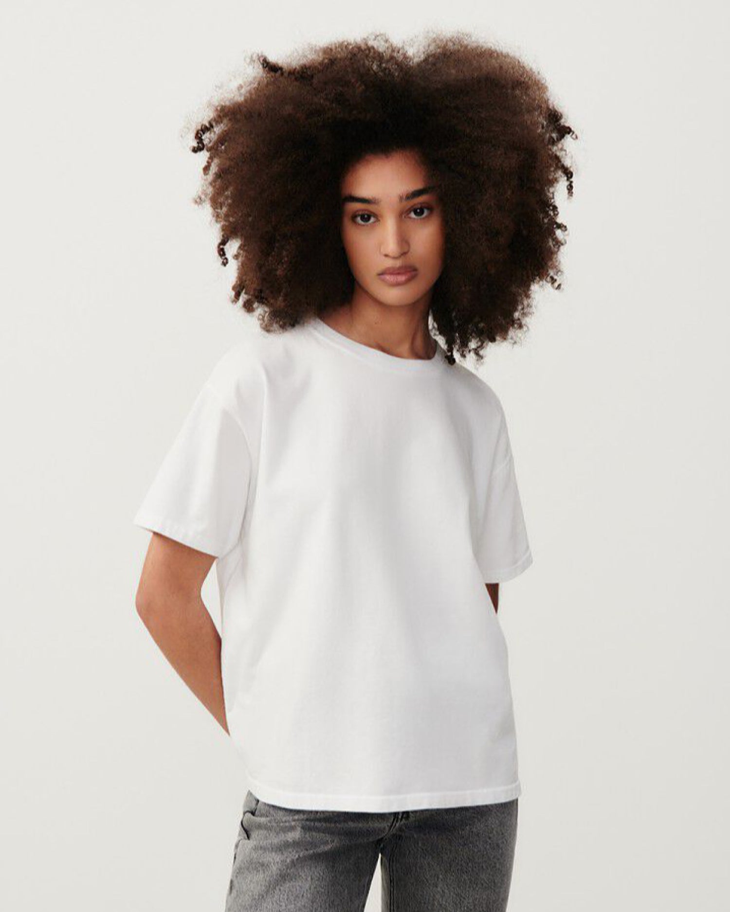 A model wears a white round neck tee with short sleeves