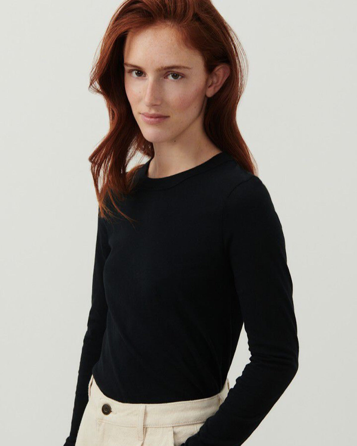 a model wears a long sleeve black T-Shirt with a high round neck