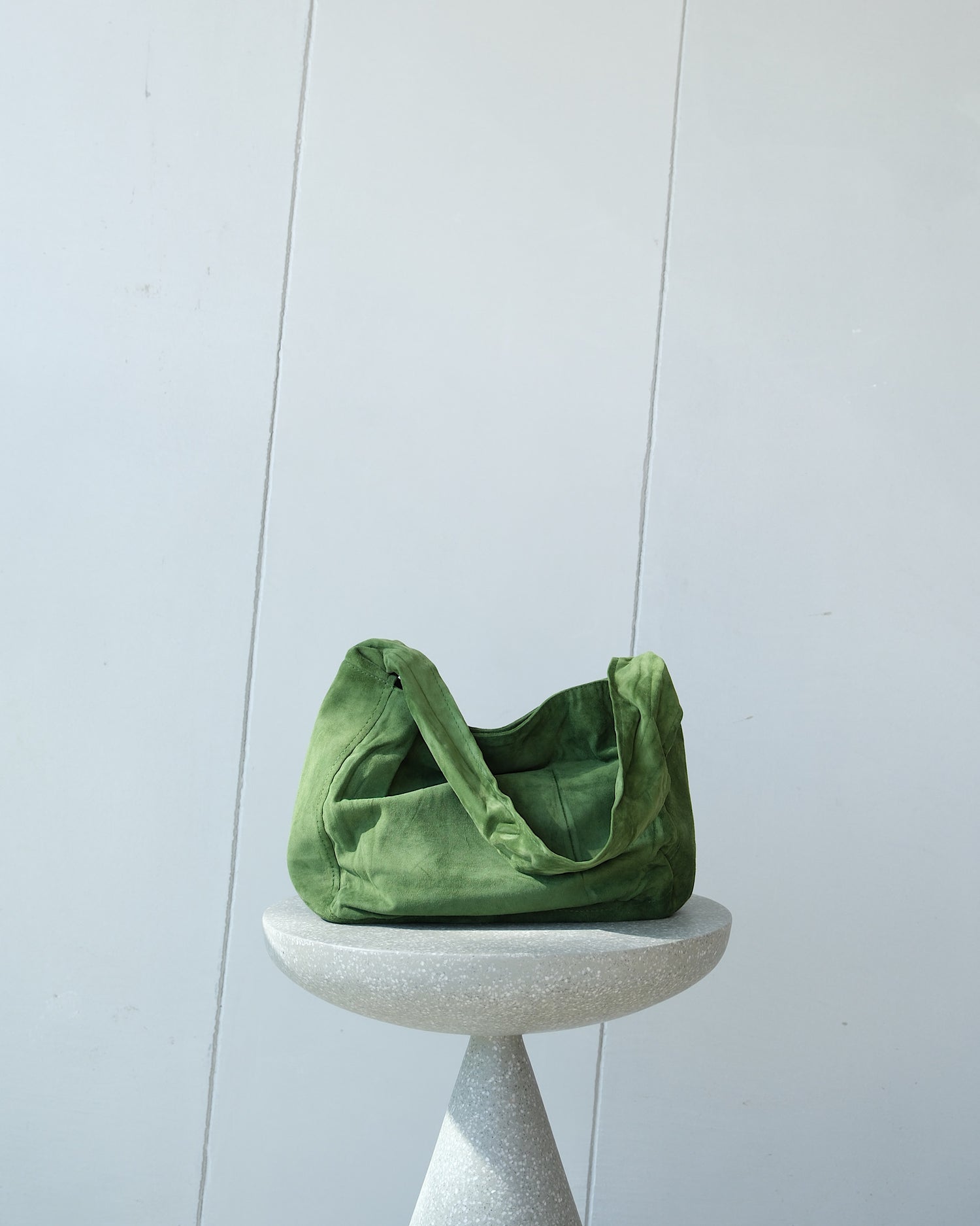 a mid green bag sits on a stool