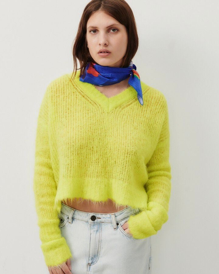 Model wears an open weave crop v neck fluffy neon yellow sweater