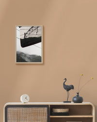 Framed artwork on a beige wall above a console table with decorative items.