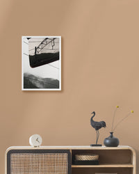 Framed landscape photograph on a beige wall above a wooden console table with decorative items.