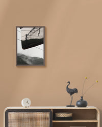 Framed landscape photograph on a beige wall above a console table with decorative items.