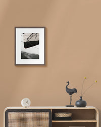 Framed artwork on a beige wall above a wooden console table with decorative items.