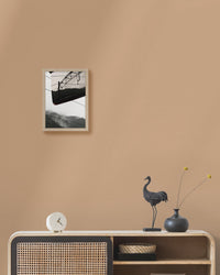 Framed artwork on a beige wall above a console table with decorative items.