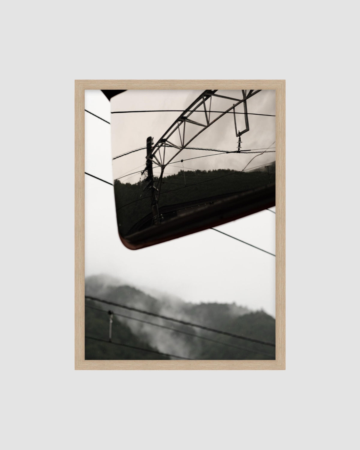 Framed Japanese landscape photograph of power lines against a mountainous landscape.