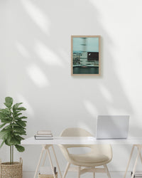 Modern office setup with a desk, chair, and framed picture on a white wall.