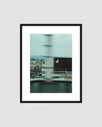 Framed artwork of a cityscape with a blurred glass surface
