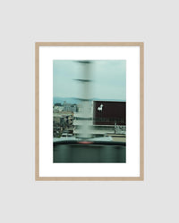 Framed artwork of a cityscape with a blurred effect on a white wall