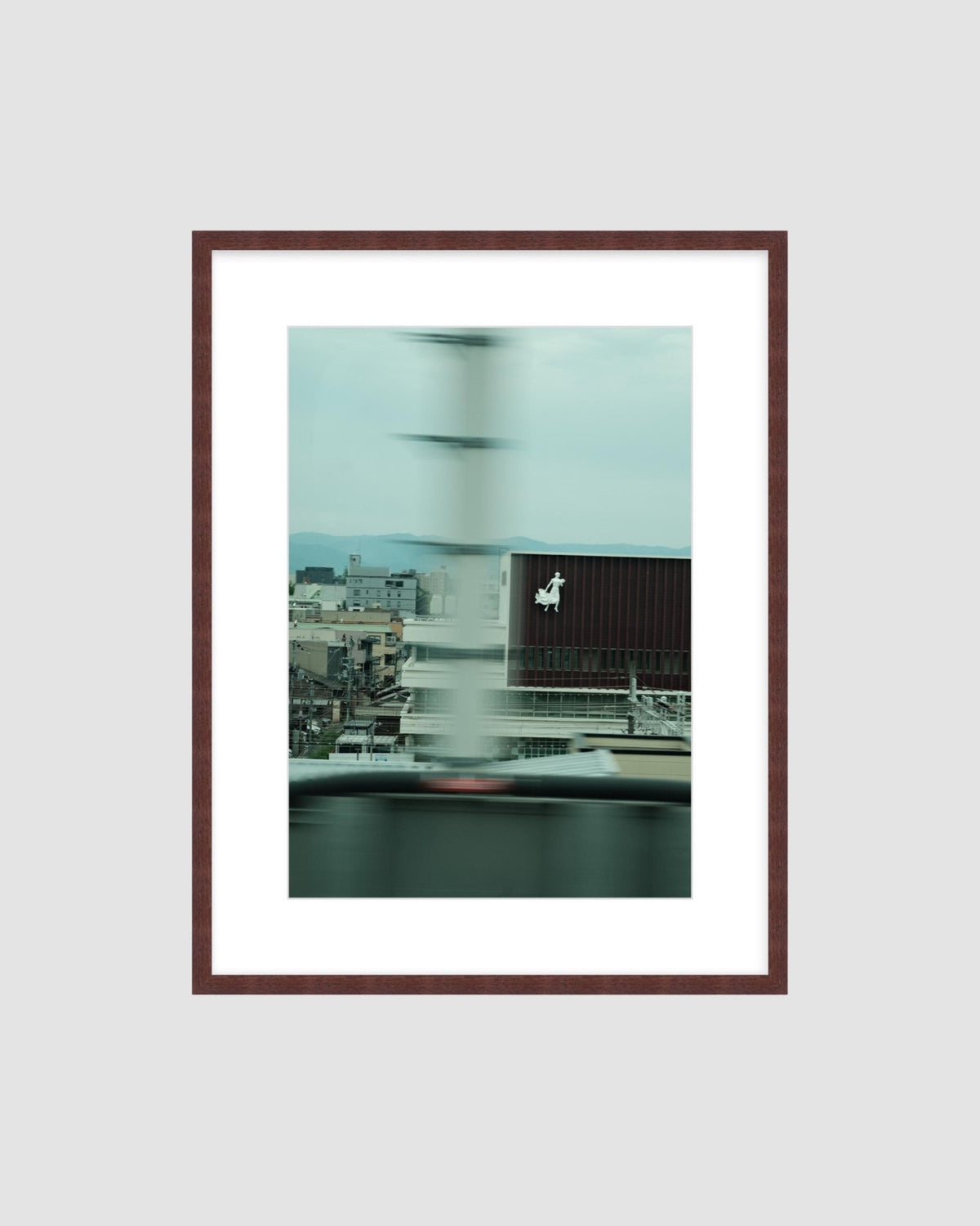 Framed artwork of a cityscape with a blurred background on a light gray background
